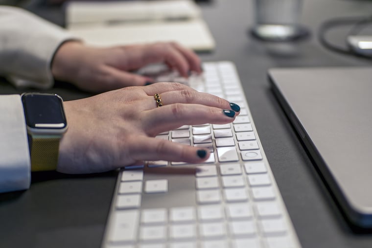 Hände einer Frau, die auf einer Tastatur tippt